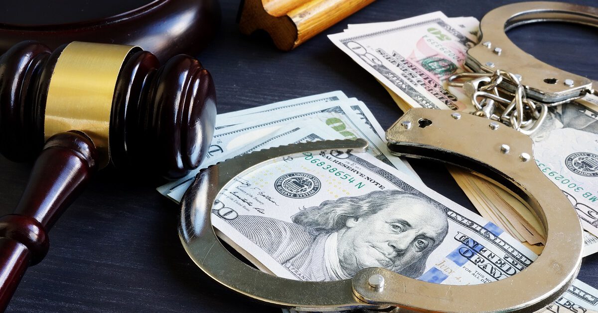 Handcuffs and gavel on stack of bills